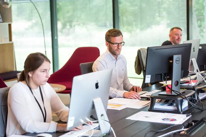 Tre collaboratori in ufficio a lavoro al computer | Qipo