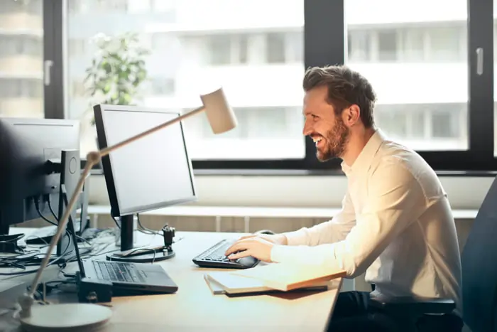 Un lavoratore al computer sereno e felice | Qipo